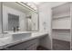 Bathroom vanity with large mirror, gray cabinets, and accessible walk-in closet at 1100 E Vernoa St, San Tan Valley, AZ 85140