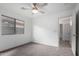 Neutral bedroom with a ceiling fan, window, and doorway at 1100 E Vernoa St, San Tan Valley, AZ 85140