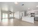 Open-concept living space with wood-look floors that flow into a kitchen with white counter tops and stainless appliances at 1100 E Vernoa St, San Tan Valley, AZ 85140