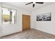 Well-lit bedroom with tiled floor, ceiling fan, double door closet and window view at 11686 N Spotted Horse Way, Fountain Hills, AZ 85268