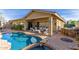 Outdoor patio featuring a sparkling pool, covered seating area, and lush landscaping at 12320 W Lone Tree Trl, Peoria, AZ 85383