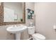 Charming powder room featuring a pedestal sink, mosaic mirror, and decorative storage at 12320 W Lone Tree Trl, Peoria, AZ 85383