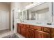 Elegant bathroom with dual sinks, wooden cabinetry, and a large mirror with stylish lighting at 12320 W Lone Tree Trl, Peoria, AZ 85383