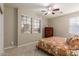 Cozy bedroom with a patterned bedspread, ceiling fan, and natural light through the windows at 12320 W Lone Tree Trl, Peoria, AZ 85383