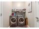 Functional laundry room with a front-load washer, dryer, and storage shelves at 12320 W Lone Tree Trl, Peoria, AZ 85383