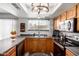 Traditional kitchen featuring wood cabinets, neutral countertops, stainless steel appliances, and modern lighting at 12402 N 36Th Dr, Phoenix, AZ 85029