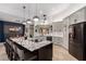 Modern kitchen featuring a large island with seating, granite countertops, and stainless steel appliances at 1356 E Desert Flower Ln, Phoenix, AZ 85048