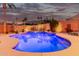 Backyard view of the pool lit up at night with colorful lighting, desert plants, and landscape lighting at 1356 E Desert Flower Ln, Phoenix, AZ 85048