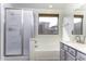 Bathroom featuring a shower, bathtub, window, and vanity with gray cabinets at 1391 E 12Th St, Casa Grande, AZ 85122