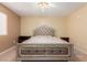 Bedroom featuring tile flooring, a ceiling fan, and a statement upholstered king-size bed at 1422 S 231St Ln, Buckeye, AZ 85326