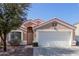 Charming single-story home featuring a well-maintained front yard, two-car garage, and a terracotta-tiled roof at 1422 S 231St Ln, Buckeye, AZ 85326