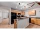 Bright kitchen features a breakfast bar, wood cabinets, tile flooring, and black appliances at 1422 S 231St Ln, Buckeye, AZ 85326