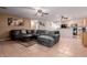 Open-concept living room with tile flooring, ceiling fan, and a comfortable gray sectional couch at 1422 S 231St Ln, Buckeye, AZ 85326