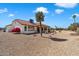 Manicured backyard featuring desert landscaping, a palm tree and a covered patio at 14710 W Yosemite Dr, Sun City West, AZ 85375