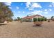 Well-maintained single-story house with a covered patio and gravel landscaping under a bright blue sky at 14710 W Yosemite Dr, Sun City West, AZ 85375