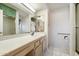 Well-lit bathroom featuring an extended vanity, large mirror and open storage at 14710 W Yosemite Dr, Sun City West, AZ 85375