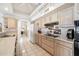 A well-lit kitchen with white tile flooring and light wood cabinets, perfect for cooking and entertaining at 14710 W Yosemite Dr, Sun City West, AZ 85375