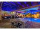 Inviting backyard patio with a dining area, lounge seating, and a sparkling pool under the soft glow of custom lighting at 1473 E Mead Dr, Chandler, AZ 85249