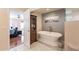 This bathroom features a standalone tub, marble floors, and a decorative cabinet in a spa-like setting at 1473 E Mead Dr, Chandler, AZ 85249