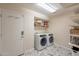 Clean laundry room with side-by-side washer and dryer and storage shelves at 1473 E Mead Dr, Chandler, AZ 85249