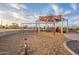 Vibrant playground area including swings, climbing structures, and engineered wood fiber safety surfacing and sun canopies at 1473 E Mead Dr, Chandler, AZ 85249