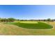 View of a well-manicured putting green in a residential community with a lush lawn and trees at 1508 W Via Del Sol --, San Tan Valley, AZ 85140