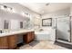 Bright bathroom featuring double sinks, a separate shower, and a soaking tub at 15620 W Meadowbrook W Ave, Goodyear, AZ 85395