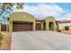 Charming home featuring a three-car garage, desert landscaping, and a welcoming entrance at 15620 W Meadowbrook W Ave, Goodyear, AZ 85395