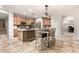 Well-lit kitchen area featuring a center island with bar seating, stainless steel appliances, and modern light fixtures at 15620 W Meadowbrook W Ave, Goodyear, AZ 85395