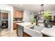 Island kitchen area with stainless steel dishwasher, farmhouse sink, shaker cabinets, and a large island with a seating area at 15620 W Meadowbrook W Ave, Goodyear, AZ 85395