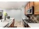 Kitchen showcasing a modern stainless steel range, overhead microwave, and wooden cabinets, offering functionality and style at 15620 W Meadowbrook W Ave, Goodyear, AZ 85395