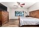 Relaxing main bedroom with wood-look floors and a window view to the outdoor pool and patio at 15620 W Meadowbrook W Ave, Goodyear, AZ 85395