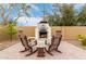 Relax in the backyard by the outdoor fireplace with built-in seating and desert landscaping at 15620 W Meadowbrook W Ave, Goodyear, AZ 85395