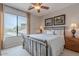 Bedroom featuring a large window, ceiling fan and metal bed frame, filled with natural light at 16203 E Ridgeline Dr, Fountain Hills, AZ 85268