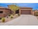 Attractive home featuring a brown garage door, desert landscaping, and paved driveway at 16203 E Ridgeline Dr, Fountain Hills, AZ 85268