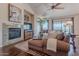 Comfortable living room featuring a fireplace, ceiling fan, and lots of natural light at 16203 E Ridgeline Dr, Fountain Hills, AZ 85268