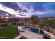 Aerial view of a luxurious backyard with a pool, spa, putting green, and beautiful landscaping at sunset at 16646 S 16Th St, Phoenix, AZ 85048