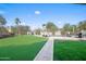 Well-manicured backyard with artificial turf, stone walkway, putting green, and swimming pool at 16646 S 16Th St, Phoenix, AZ 85048