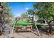 Relaxing backyard featuring a charming wooden swing set amidst a beautifully landscaped yard and putting green at 16646 S 16Th St, Phoenix, AZ 85048