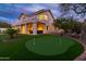 Picturesque backyard featuring a putting green, covered patio, and mature trees, creating a perfect outdoor retreat at 16646 S 16Th St, Phoenix, AZ 85048