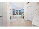 Bright bathroom with a soaking tub under a large window, a walk-in shower, and tile flooring at 16646 S 16Th St, Phoenix, AZ 85048