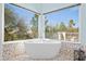 Bright bathroom features a soaking tub with scenic views and pebble tile floor at 16646 S 16Th St, Phoenix, AZ 85048