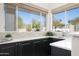 Kitchen bar featuring a bar top, sink, and large windows overlooking backyard at 16646 S 16Th St, Phoenix, AZ 85048