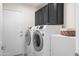 Laundry room with dark wood cabinets, tile floor and new model washer and dryer at 16646 S 16Th St, Phoenix, AZ 85048