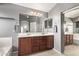 Bathroom featuring double sinks, wood cabinets, and a large mirror at 17574 W Corrine Dr, Surprise, AZ 85388