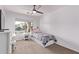 Bright bedroom featuring a ceiling fan, a large window, and a comfortable single bed with storage drawers at 17574 W Corrine Dr, Surprise, AZ 85388