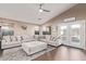 Bright living room with a large sectional sofa, neutral decor, and wood-look floors at 17574 W Corrine Dr, Surprise, AZ 85388