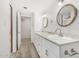 Bright bathroom featuring double sinks, wood framed mirror, and a walk-in closet at 1817 W Claremont St, Phoenix, AZ 85015