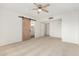 A bedroom with neutral carpet and a sliding barn door to bathroom at 1817 W Claremont St, Phoenix, AZ 85015