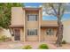 Charming two-story townhome featuring a secure front entry, desert landscaping, and a mature tree at 1817 W Claremont St, Phoenix, AZ 85015